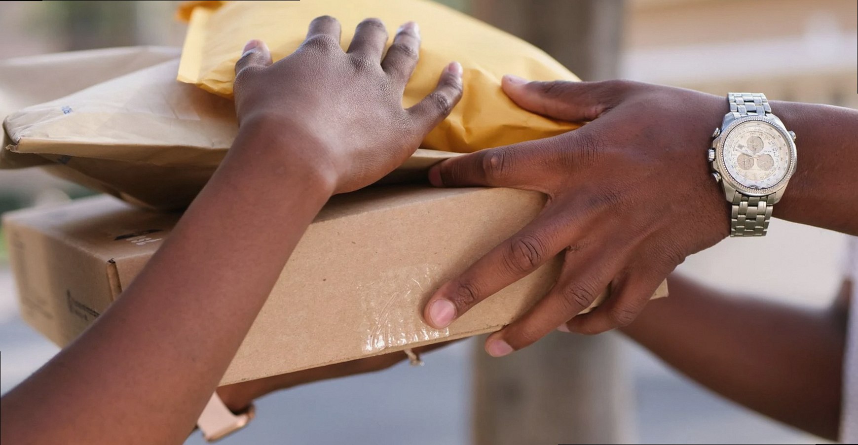 Two individuals exchanging cardboard and padded envelopes, representing delivery services.