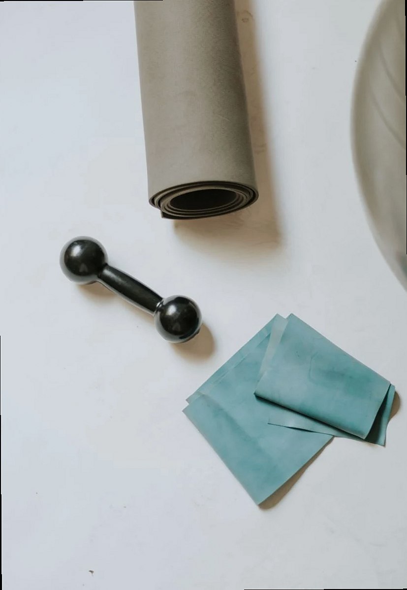 A flat lay of home workout essentials including a mat, dumbbell, and resistance band.